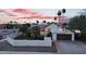 Exterior shot of a home with solar panels, a green lawn, palm trees, and a warm, inviting ambiance at 1940 E Citation Ln, Tempe, AZ 85284