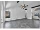 Airy living room featuring vaulted ceilings, modern fan, striking beams, neutral paint, and unique stone flooring at 1940 E Citation Ln, Tempe, AZ 85284