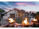 Outdoor living space with a pool, stone patio, and fire bowls, perfect for entertaining under the sunset at 1940 E Citation Ln, Tempe, AZ 85284