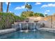 Stunning pool with beautiful tiled waterfall feature surrounded by lush landscaping at 1940 E Citation Ln, Tempe, AZ 85284