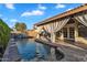 Inviting backyard pool with a covered patio, waterfall feature and stone tile surround at 1940 E Citation Ln, Tempe, AZ 85284