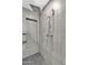 Modern shower with gray tile, pebble floor, and a rain shower head fixture at 1940 E Citation Ln, Tempe, AZ 85284