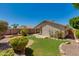 Backyard featuring lush landscaping, grassy area, rock accents, and a covered patio at 19851 N 35Th St, Phoenix, AZ 85050