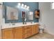Bathroom boasts double sinks, wooden cabinetry, and stylish blue accent wall at 19851 N 35Th St, Phoenix, AZ 85050