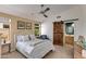 Comfortable bedroom with a ceiling fan and a rustic sliding barn door to the bathroom at 19851 N 35Th St, Phoenix, AZ 85050