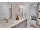 Stylish bathroom with double vanity, quartz countertop, and doorway view to bedroom at 20649 E Vallejo Ct, Queen Creek, AZ 85142