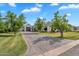 Long driveway leading to home and garage, framed by mature trees and well-maintained lawns at 20649 E Vallejo Ct, Queen Creek, AZ 85142