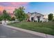 Charming white brick home with lush green lawn and elegant white rose bushes along the pathway at 20649 E Vallejo Ct, Queen Creek, AZ 85142
