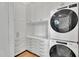 A dedicated laundry room with white cabinets, ample counter space, and stacked washer and dryer at 20649 E Vallejo Ct, Queen Creek, AZ 85142
