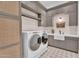 Well-organized laundry room with modern washer and dryer, sink and custom cabinets at 20649 E Vallejo Ct, Queen Creek, AZ 85142