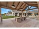 Elegant outdoor dining area under a covered patio with a large table, seating, and views of the expansive backyard at 20649 E Vallejo Ct, Queen Creek, AZ 85142