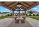 Outdoor kitchen and dining area featuring a built-in grill, pizza oven, and large table under a timber pavilion at 20649 E Vallejo Ct, Queen Creek, AZ 85142