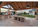 A luxurious outdoor kitchen features a built-in grill, dining area, and ambient lighting for alfresco entertaining at 20649 E Vallejo Ct, Queen Creek, AZ 85142