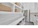 Well-organized pantry with open shelving, woven baskets, and stainless steel refrigerator at 20649 E Vallejo Ct, Queen Creek, AZ 85142