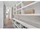 Walk-in pantry with ample storage shelves, decorative baskets, and tiled backsplash at 20649 E Vallejo Ct, Queen Creek, AZ 85142