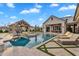 Luxurious pool area with a sun loungers, pool, and fire pit with a pavilion in the background at 20649 E Vallejo Ct, Queen Creek, AZ 85142