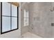 Modern shower with glass door, gray tiled walls, niche and black-framed window at 20649 E Vallejo Ct, Queen Creek, AZ 85142