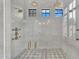 This bright walk-in shower features marble walls, rain shower heads, and transom windows at 20649 E Vallejo Ct, Queen Creek, AZ 85142