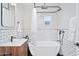 Bright bathroom featuring subway tile, floating vanity, and a modern soaking tub with black hardware at 2227 N 16Th Ave, Phoenix, AZ 85007
