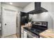 Kitchen featuring stainless steel appliances, black range hood, white cabinets, and butcher block countertops at 2227 N 16Th Ave, Phoenix, AZ 85007
