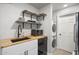 Kitchen with stainless steel appliances, floating shelves, and modern sink with black faucet and white cabinets at 2227 N 16Th Ave, Phoenix, AZ 85007