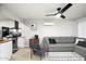 Open concept living space with gray sofa, black ceiling fan, and seamless flow to the adjacent kitchen at 2227 N 16Th Ave, Phoenix, AZ 85007