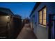 Narrow pathway featuring a brick walkway, black privacy fence, and exterior house lighting at 2227 N 16Th Ave, Phoenix, AZ 85007