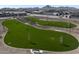 Aerial view of a community dog park featuring fenced areas and lush green spaces for pets to enjoy at 22699 E Happy Rd, Queen Creek, AZ 85142