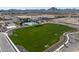 Aerial view of community common area featuring a clubhouse, pool, playground, and green space at 22705 E Happy Rd, Queen Creek, AZ 85142