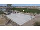 An outdoor basketball court is shown in a community with green grass, benches and a covered picnic area at 22705 E Happy Rd, Queen Creek, AZ 85142