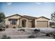 Charming single story home displaying neutral toned stucco, tile roof, covered porch, three car garage and desert landscaping at 22705 E Happy Rd, Queen Creek, AZ 85142