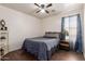 Cozy bedroom with wood floors, ceiling fan, full-sized bed, and blue curtains at 2341 S Gordon --, Mesa, AZ 85209