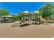 Community playground featuring slides, climbing structures, and mature shade trees on a sunny day at 2341 S Gordon --, Mesa, AZ 85209
