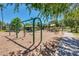 Community playground featuring swings, picnic tables, and mature shade trees on a sunny day at 2341 S Gordon --, Mesa, AZ 85209
