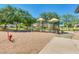 Community playground featuring slides, climbing structures, and mature shade trees on a sunny day at 2341 S Gordon --, Mesa, AZ 85209