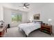 Bright bedroom features a ceiling fan, a large window, and two wooden nightstands at 2425 W Bronco Butte Trl # 2011, Phoenix, AZ 85085