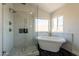 Spa-like bathroom showcasing a freestanding tub, glass-enclosed shower, and marble walls, creating a luxurious retreat at 26286 N 45Th Pl, Phoenix, AZ 85050