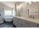 Elegant bathroom featuring a freestanding tub beneath a window, alongside a dual sink vanity with marble countertops at 26286 N 45Th Pl, Phoenix, AZ 85050