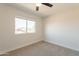 Bright bedroom with a large window offering pleasant neighborhood views, complemented by carpet flooring and neutral walls at 26286 N 45Th Pl, Phoenix, AZ 85050