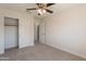Neutral bedroom featuring a ceiling fan, carpeted floor, closet, and an ensuite bathroom, all contributing to a comfortable atmosphere at 26286 N 45Th Pl, Phoenix, AZ 85050