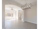 Open-concept living room featuring an arched entrance, tile floors, and a modern light fixture at 26286 N 45Th Pl, Phoenix, AZ 85050