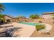 Backyard pool featuring mature landscaping, a stone fence and a well-maintained yard, creating a private oasis at 26286 N 45Th Pl, Phoenix, AZ 85050