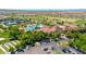 Community aerial view featuring a swimming pool, tennis courts, green golf course, mature trees, and parking at 27606 W Tonopah Dr, Buckeye, AZ 85396