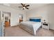 Bright bedroom with a ceiling fan, a king bed with blue pillows, and an ensuite bathroom at 27606 W Tonopah Dr, Buckeye, AZ 85396