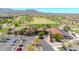 A landscape view of the clubhouse surrounded by a lush green golf course with mature trees at 27606 W Tonopah Dr, Buckeye, AZ 85396
