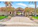 Inviting entrance to the clubhouse with a covered walkway lined with trees and flowering plants in decorative pots at 27606 W Tonopah Dr, Buckeye, AZ 85396