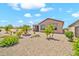 Landscaped backyard featuring gravel, green plants, and a covered patio at 27606 W Tonopah Dr, Buckeye, AZ 85396