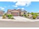 Charming single-story home with a well-manicured desert landscape, two-car garage, and beautiful tile roof at 27606 W Tonopah Dr, Buckeye, AZ 85396
