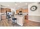 Open kitchen featuring a center island, stainless steel appliances, granite countertops, and wood-look flooring at 27606 W Tonopah Dr, Buckeye, AZ 85396