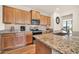 Well-lit kitchen features wooden cabinetry, granite countertops, and modern stainless steel appliances at 27606 W Tonopah Dr, Buckeye, AZ 85396